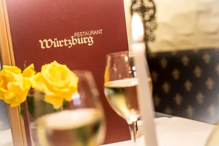 Tisch mit Speisenkarte, gelben Rosen und Weingläsern auf der Seite Jobs
