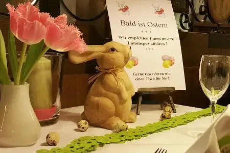 Osterarrangement mit Blumen und einem Osterhasen