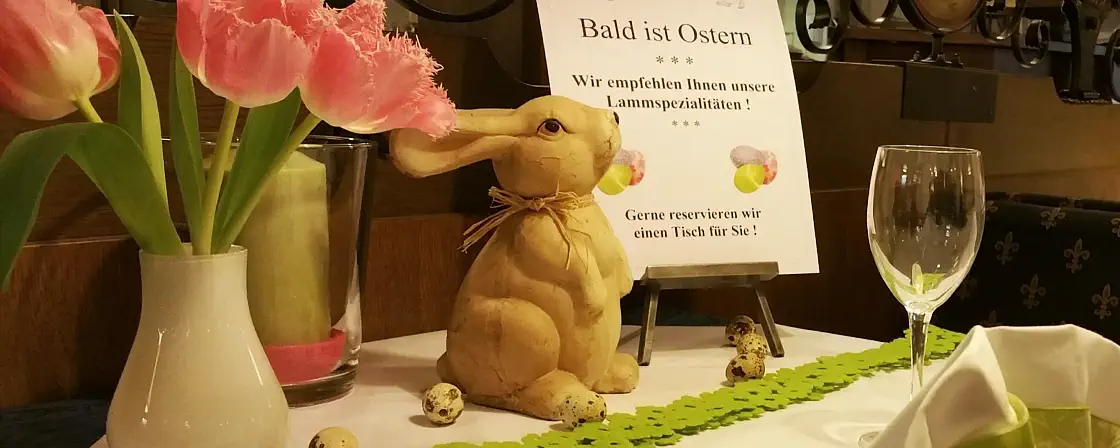 Osterarrangement mit Blumen und einem Osterhasen